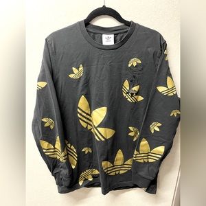 Adidas black long sleeve shirt with shimmery gold adidas logo pattern
